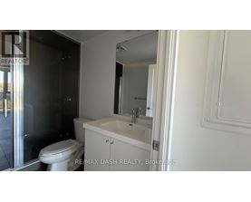 A white bathroom with a toilet, sink and mirror.