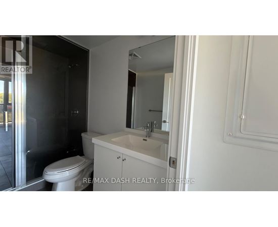 A white bathroom with a toilet, sink and mirror.