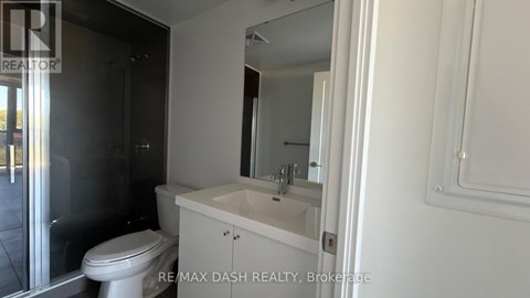 A white bathroom with a toilet, sink and mirror.