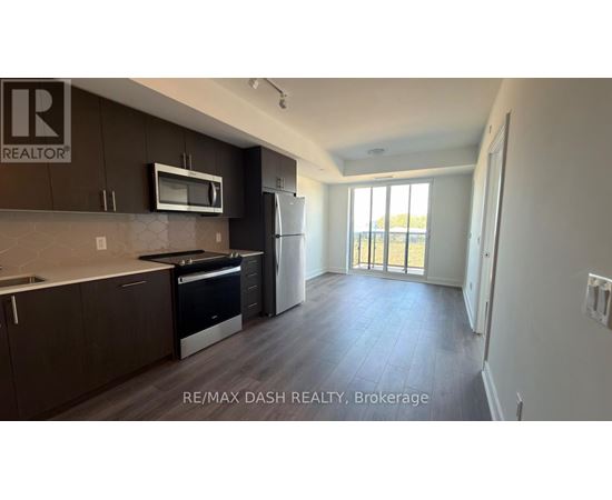 A kitchen with dark brown cabinets and a microwave above the stove.