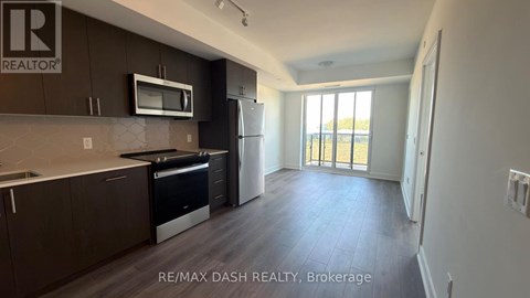 A kitchen with dark brown cabinets and a microwave above the stove.