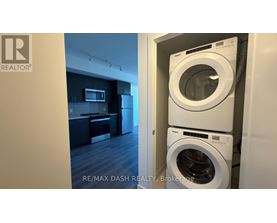 A washing machine is in a cabinet in a room.