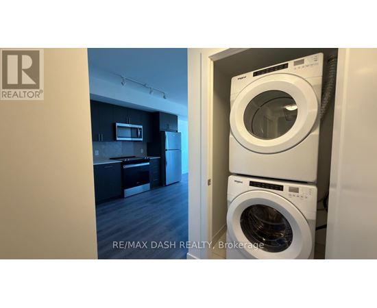 A washing machine is in a cabinet in a room.