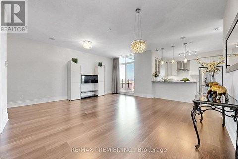 A spacious living room with wood flooring and a dining area with a table set for two.