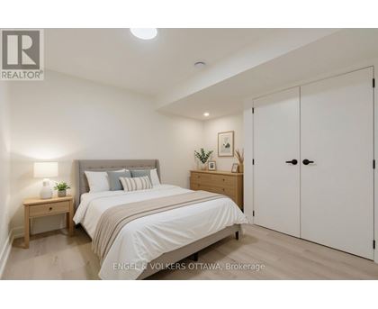 A bedroom with a bed, nightstand, and wardrobe.