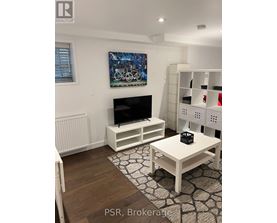 A living room with a television and a painting on the wall.