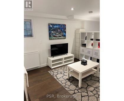 A living room with a television and a painting on the wall.