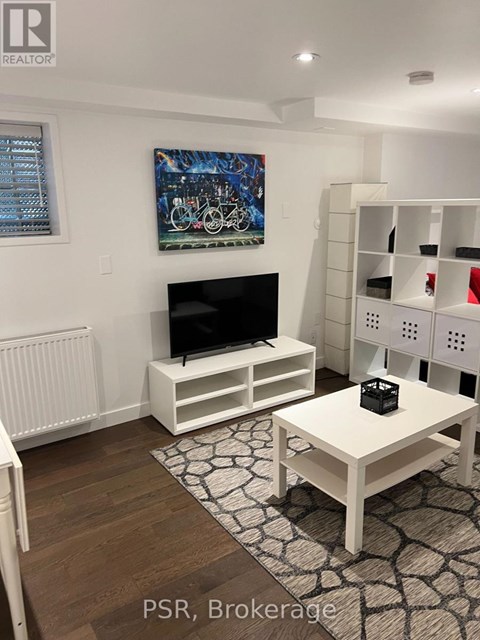 A living room with a television and a painting on the wall.