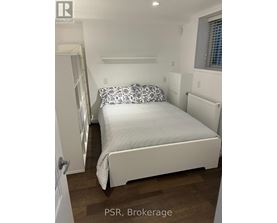 A bedroom with a bed, pillows, and a window.