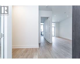 A spacious room with wooden flooring and white walls.