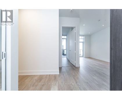 A spacious room with wooden flooring and white walls.
