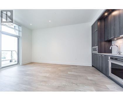 A spacious kitchen with wooden cabinets and a large window.