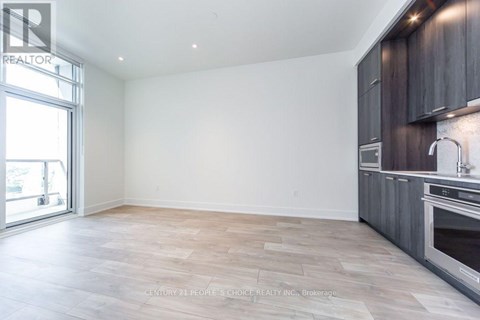 A spacious kitchen with wooden cabinets and a large window.