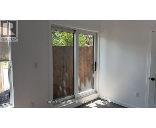 A white door with a glass window and a wooden fence outside.