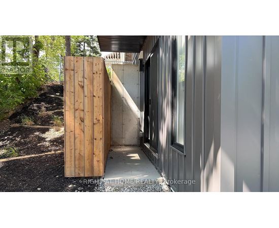 A wooden door is open to a modern house.