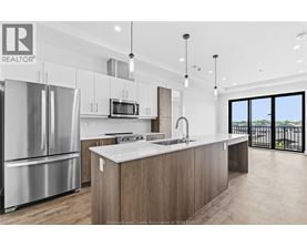 A modern kitchen with stainless steel appliances and a large island.