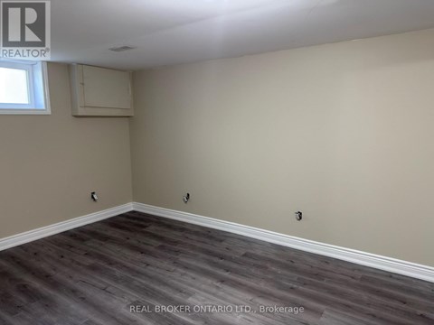 A room with a window and a grey floor.