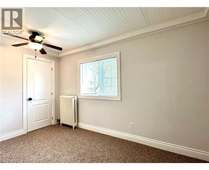 A room with a ceiling fan and a window with blinds.