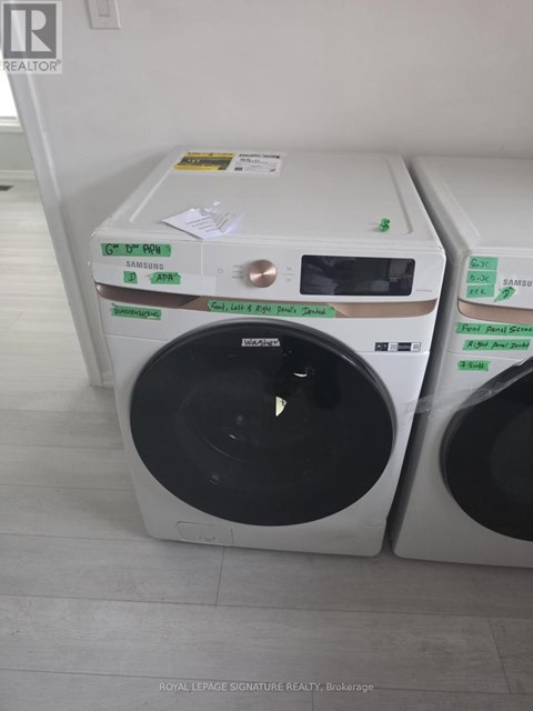 A white front loading washing machine with a green sticker on the top.