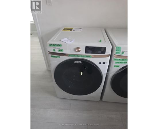 A white front loading washing machine with a green sticker on the top.