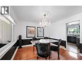 A dining room with a table set for two and a chandelier.