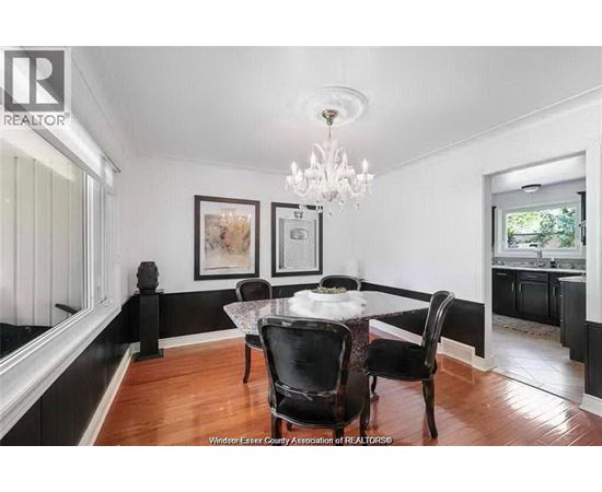 A dining room with a table set for two and a chandelier.