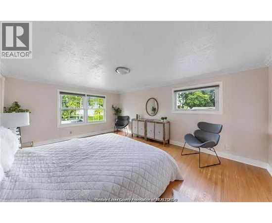 A bedroom with a large bed and a chair.