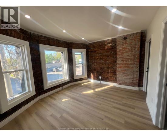 A room with a brick wall and wooden flooring.