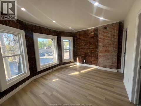 A room with a brick wall and wooden flooring.
