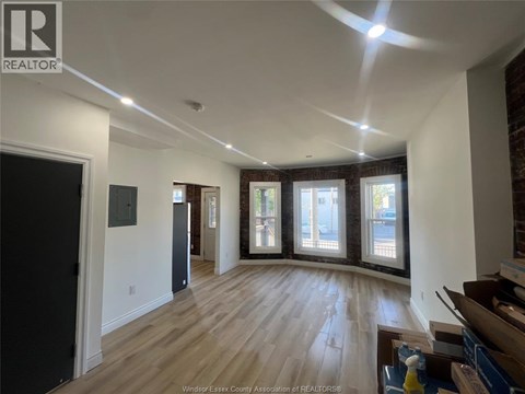 A spacious room with wooden floors and a large window.