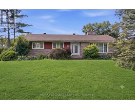 A house with a red roof and a green lawn in front.