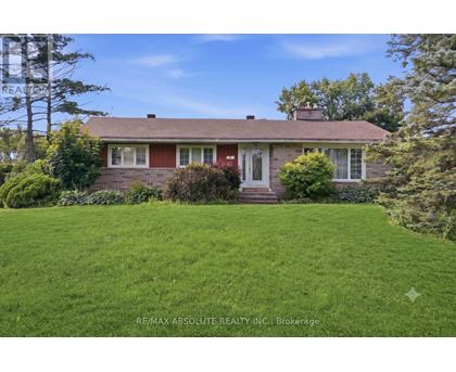 A house with a red roof and a green lawn in front.