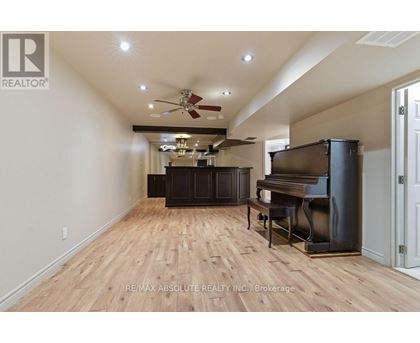 A spacious room with a piano and a fan.