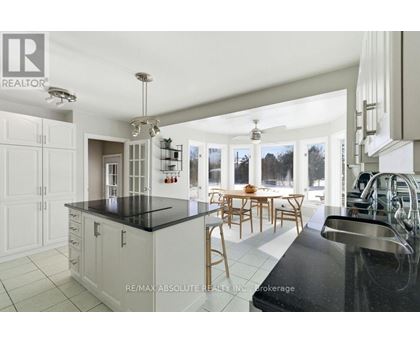 A modern kitchen with white cabinets and black countertops.