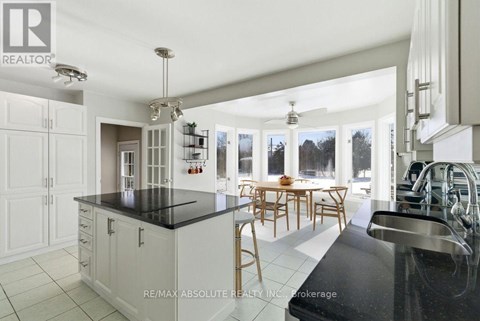 A modern kitchen with white cabinets and black countertops.
