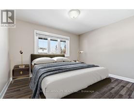 A bedroom with a bed, nightstand, and window.