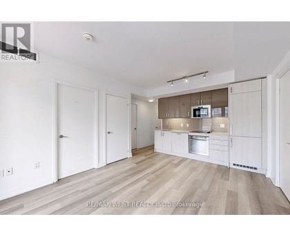 A spacious kitchen with white cabinets and a stainless steel oven.