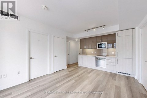 A spacious kitchen with white cabinets and a stainless steel oven.