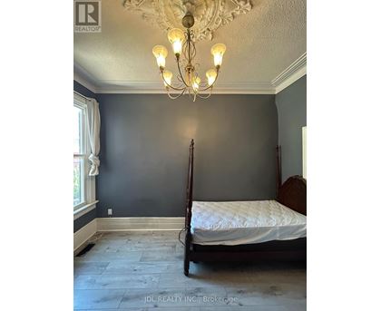 A bedroom with a four poster bed and a chandelier.