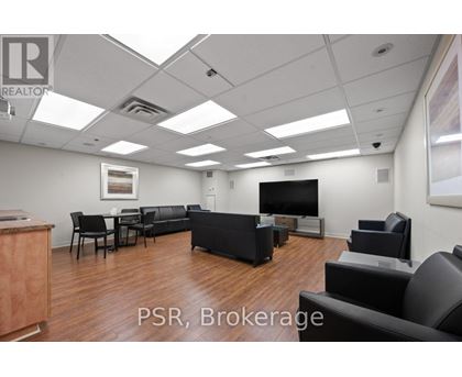 A living room with a couch, chairs, and a television.