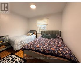 A bedroom with a bed and a window with blinds.