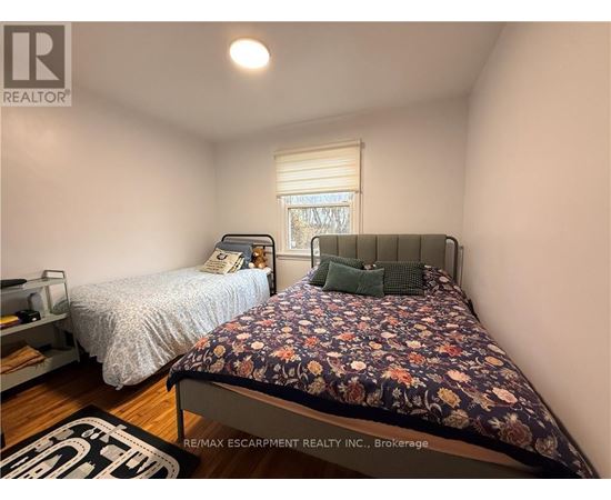 A bedroom with a bed and a window with blinds.