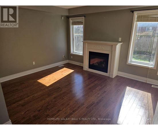 A room with a fireplace and wooden floors.