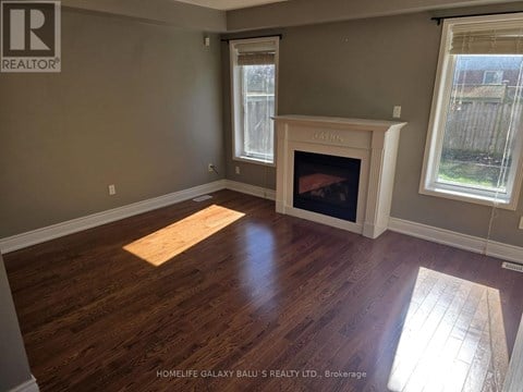 A room with a fireplace and wooden floors.