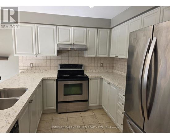 A kitchen with white cabinets and a stainless steel refrigerator.