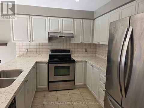 A kitchen with white cabinets and a stainless steel refrigerator.