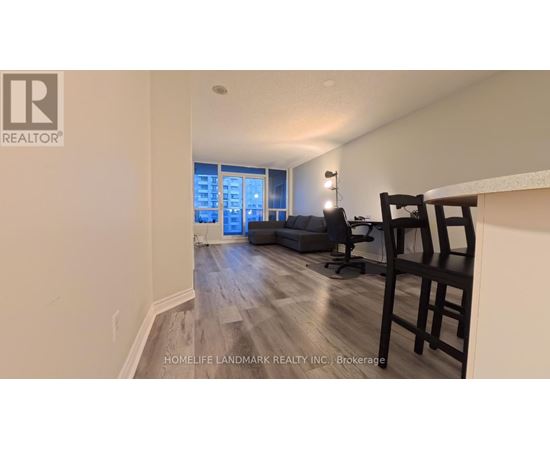 A realtor logo is on the wall of a room with a couch and chairs.