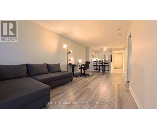 A living room with a grey couch and a wooden floor.