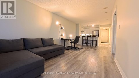 A living room with a grey couch and a wooden floor.