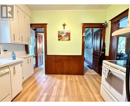A kitchen with white cabinets and a wooden wall.
